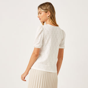 Max white pointelle knit top full length on model with cream pleated skirt and slingback heels