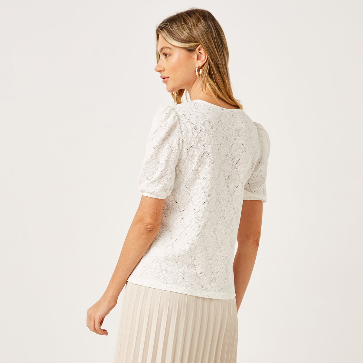 Max white pointelle knit top full length on model with cream pleated skirt and slingback heels