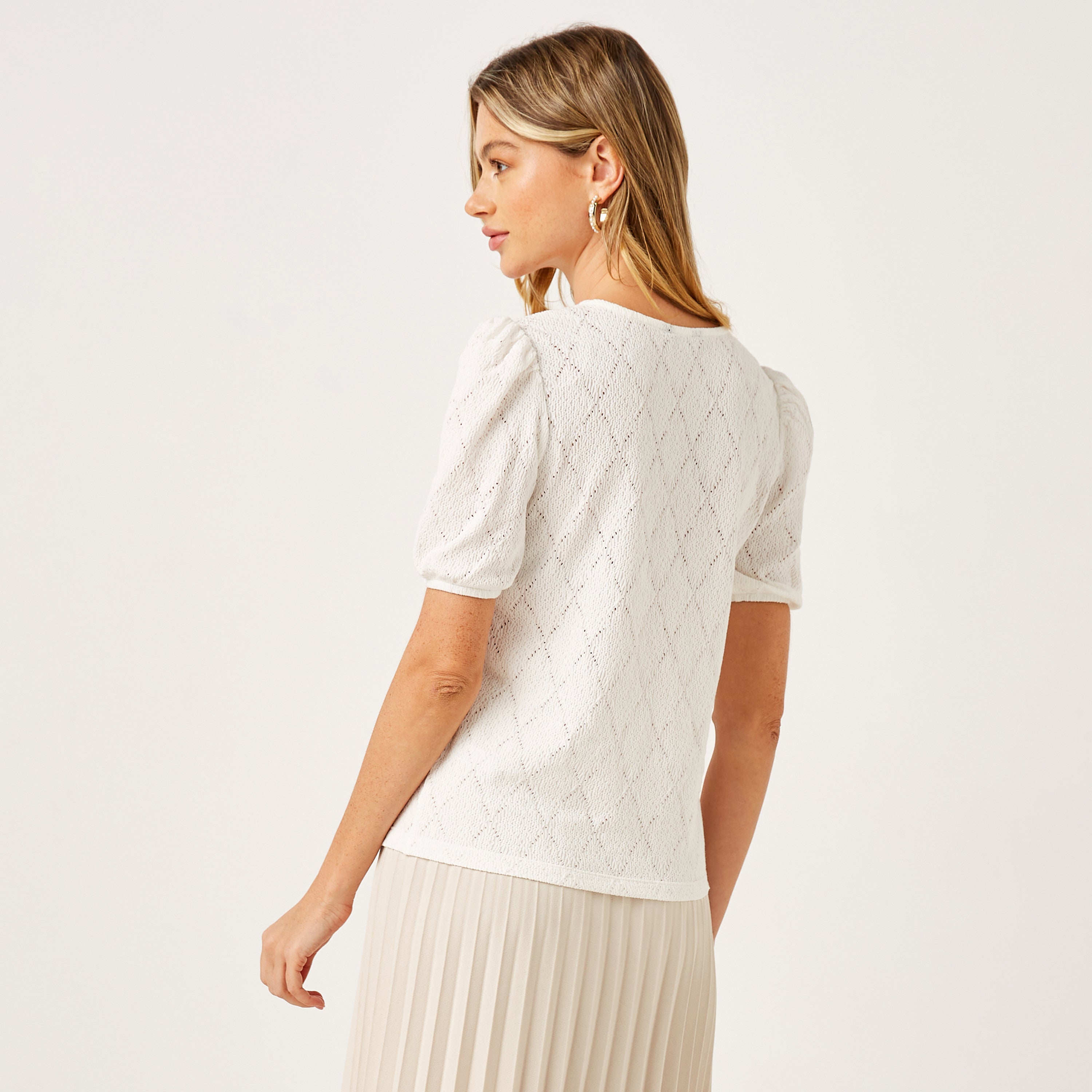 Max white pointelle knit top full length on model with cream pleated skirt and slingback heels