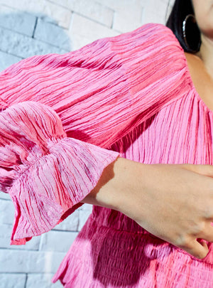 Max pink crinkle peplum top three-quarter view on model